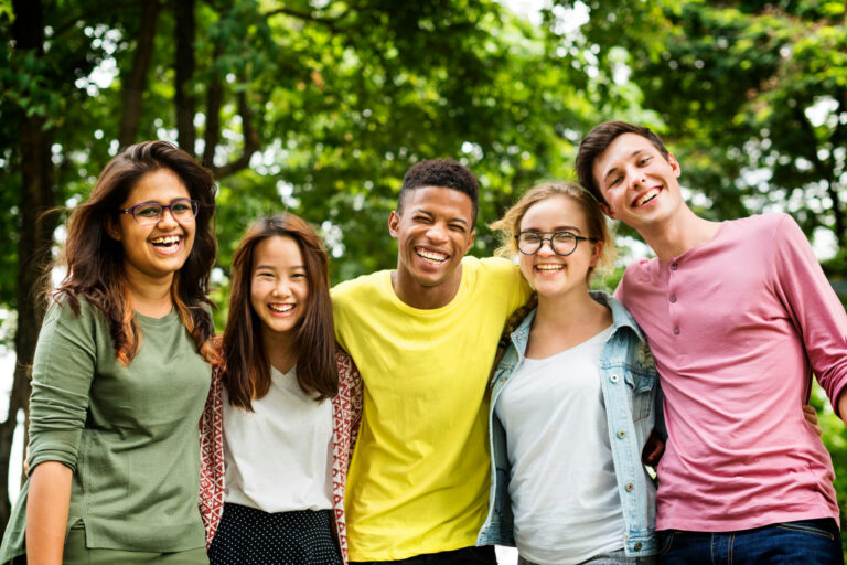 teens outside smiling together in the summer