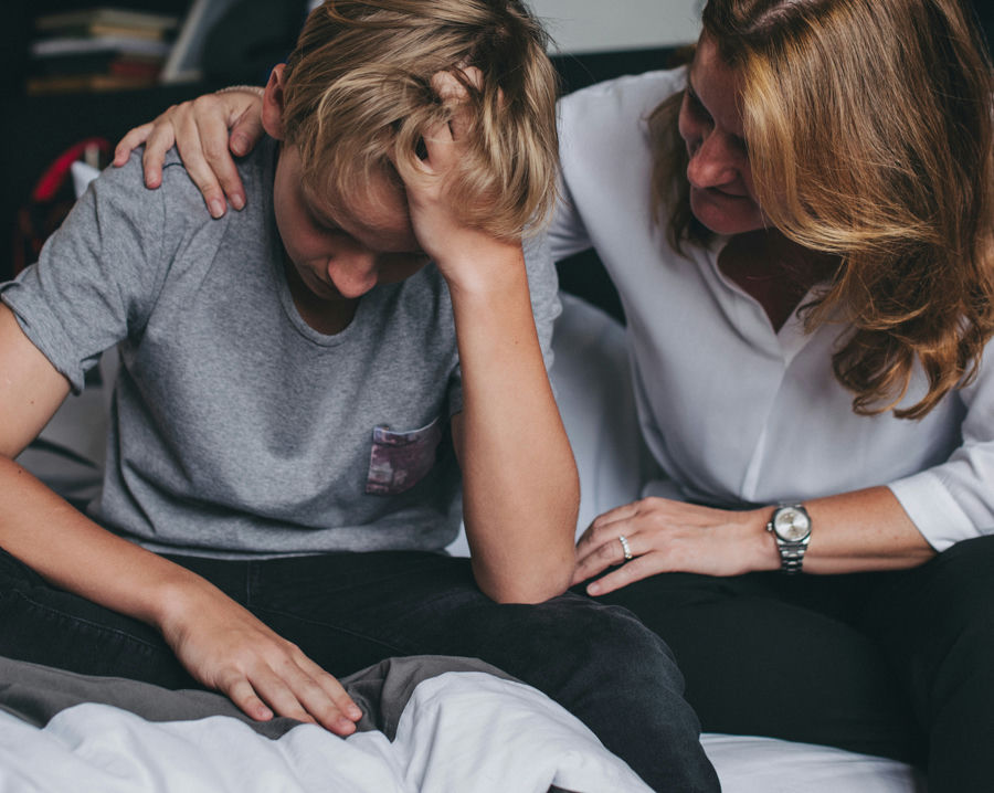 a-teen-boy-being-comforted-by-his-mom