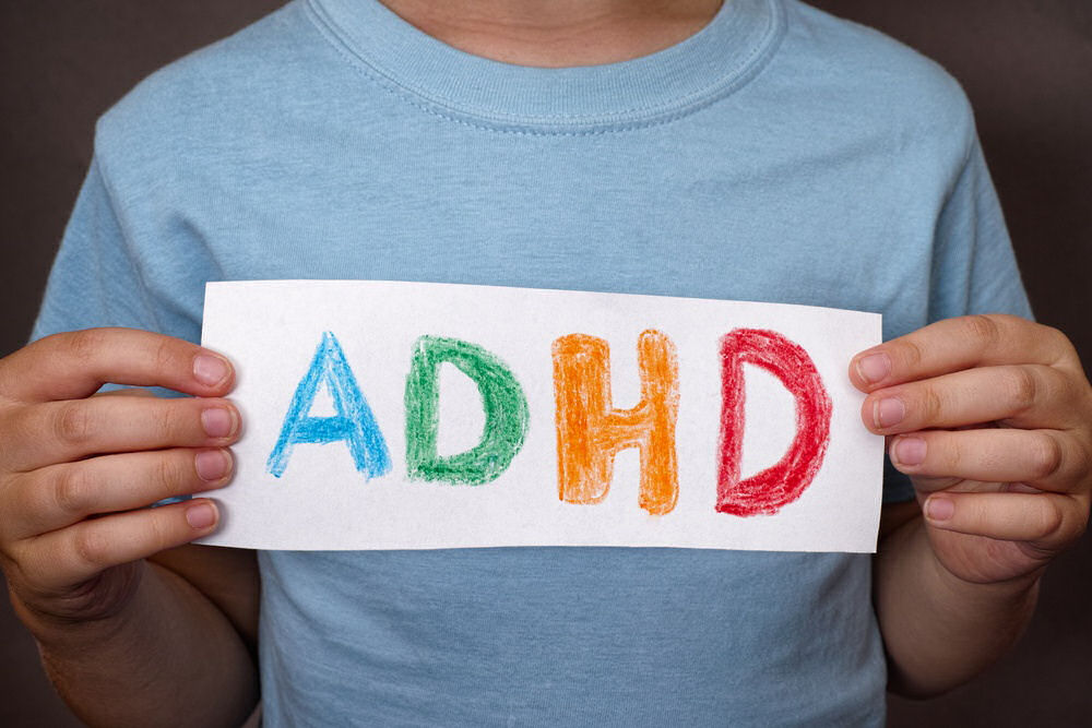 teen holding a sign that says ADHD, raising awareness and support