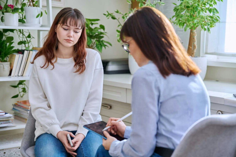 a-teen-girl-staring-at-therapist-clipboard
